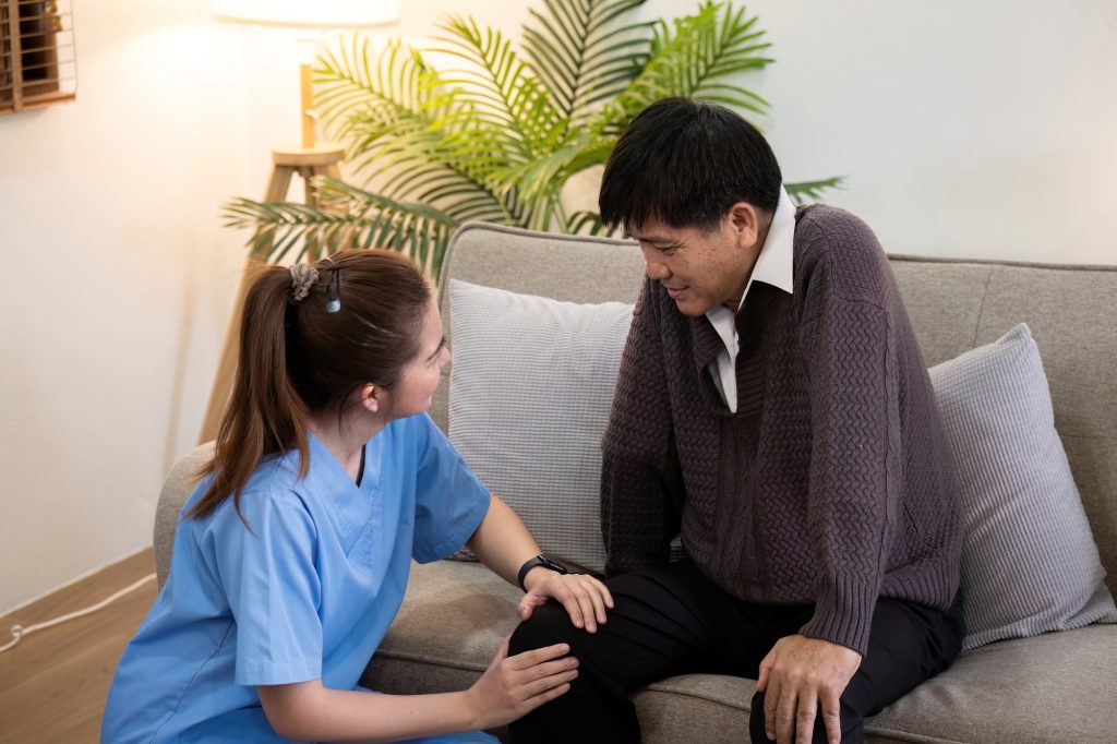 Caregiver Assisting Elderly Man with Physical Therapy at Home, Providing Support and Encouragement